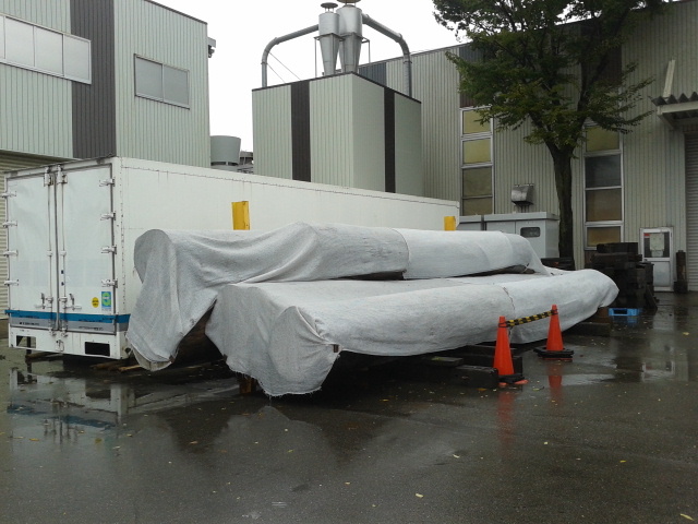 a covered pile of huge logs outside the Asano Taiko factory