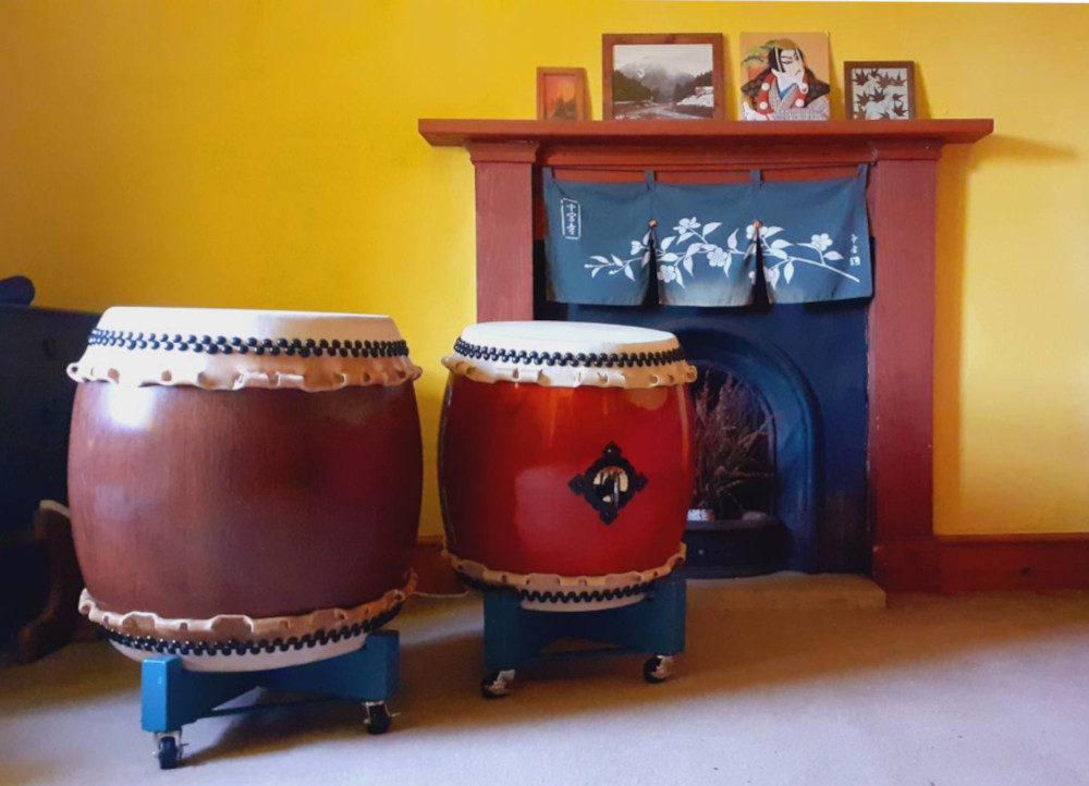 two nagados in a yellow room with photos of Kurumaya sensei and his dojo in Japan